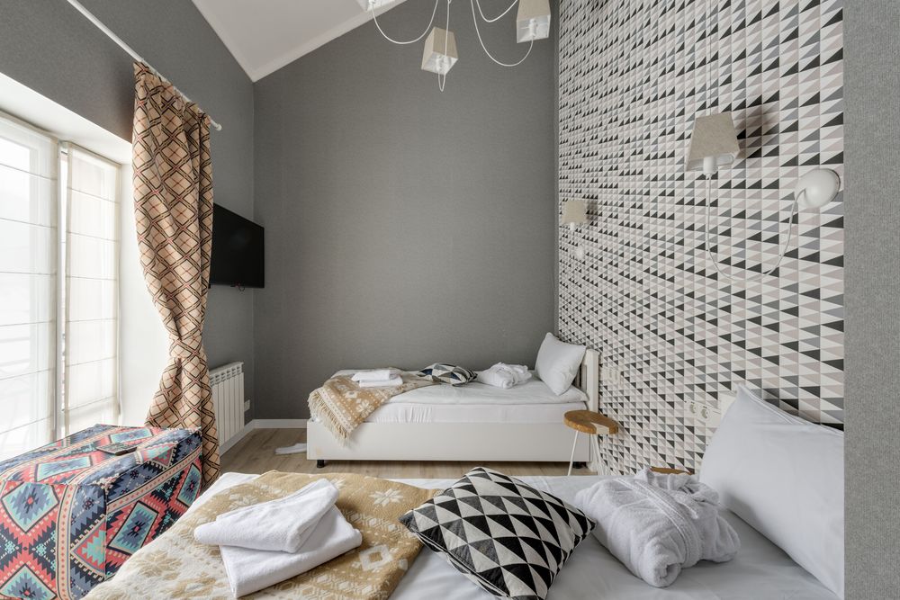 Bright bedroom with a gray and white geometric triangle wallpaper on the accent wall